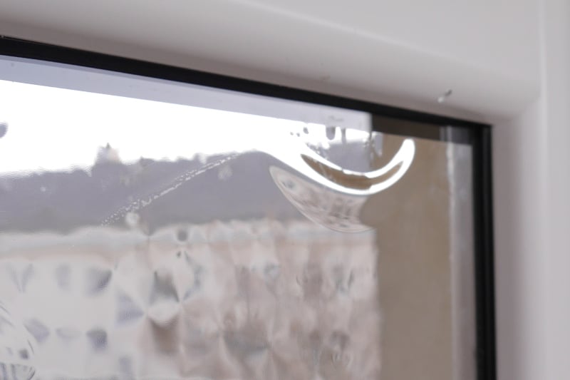 Eine Luftblase hat sich unter einer Fensterfolie gebildet