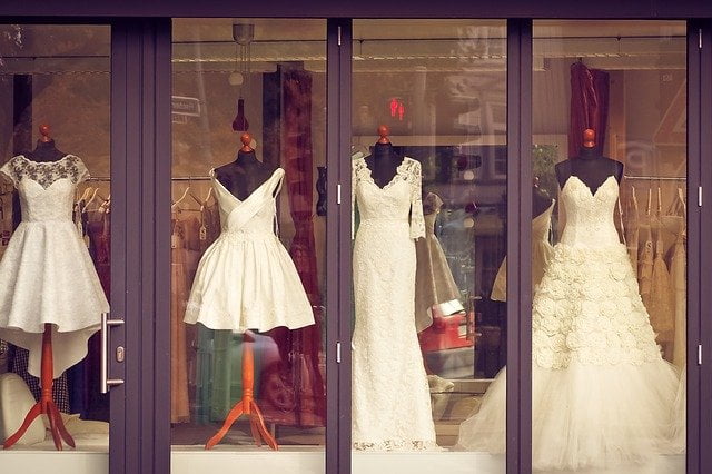 In einem Schaufenster sind verschiedene Hochzeitskleider ausgestellt