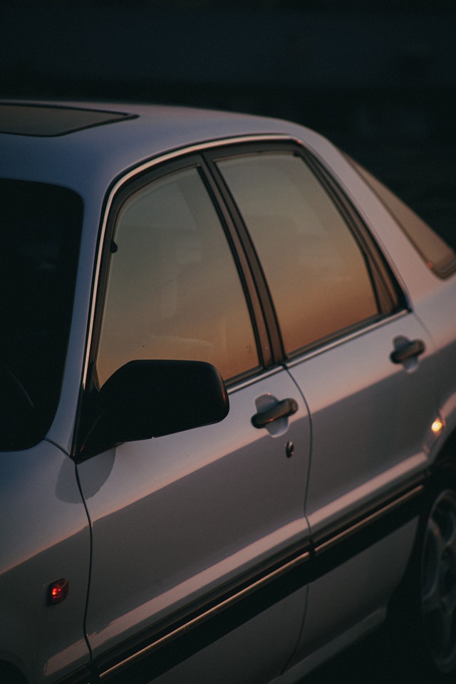 Ein Auto in dem sich der Sonnenuntergang spiegelt