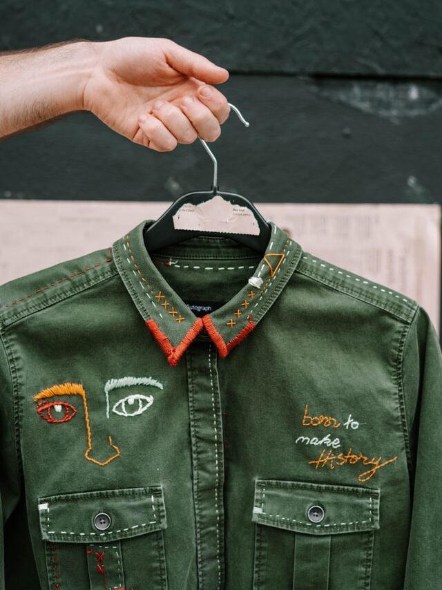 Eine grüne Jacke mit vielen bunten Stickerein