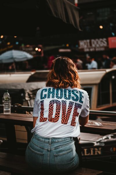 Kleidung bedrucken kann jeder. Eine Frau steht mit dem Rücken zum Betrachter. Auf Ihrem T-Shirt steht groß Choose Love