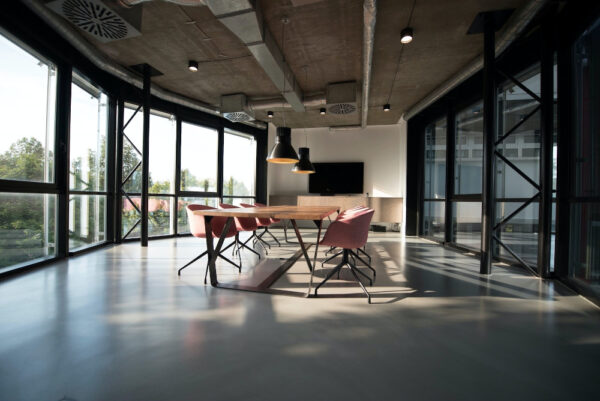 Ein Büro mit einem großen Tisch in der Mitte und umgeben von Glaswänden