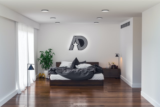 Ein Schlafzimmer im minimalistischen Stil. Neben dem Bett stehen Glasflaschen