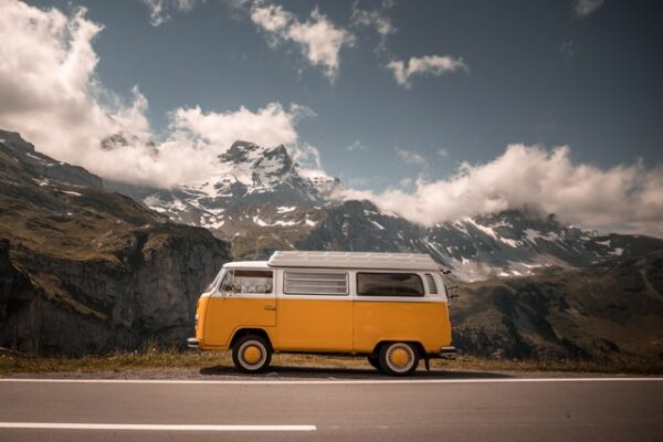 Sieht gleich wie neu aus – mit einer Außenfolierung Ein weiß-gelbes Wohnmobil steht vor einer Gebirgskulisse