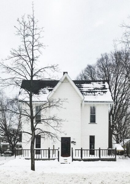 Ein Haus im Winter von dessen Dach der Schnee geschmolzen ist