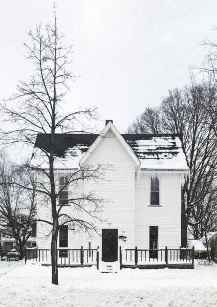 Über das Dach entweicht viel Wärme – sichtbar wird das im Winter Ein Haus im Winter von dessen Dach der Schnee geschmolzen ist
