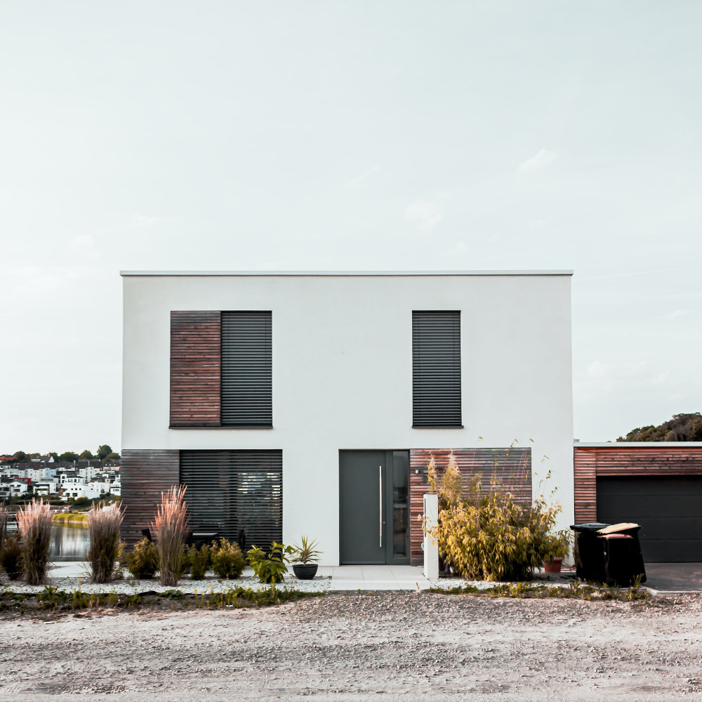 Ein modernes Haus mit großen Fenstern und Fensterläden