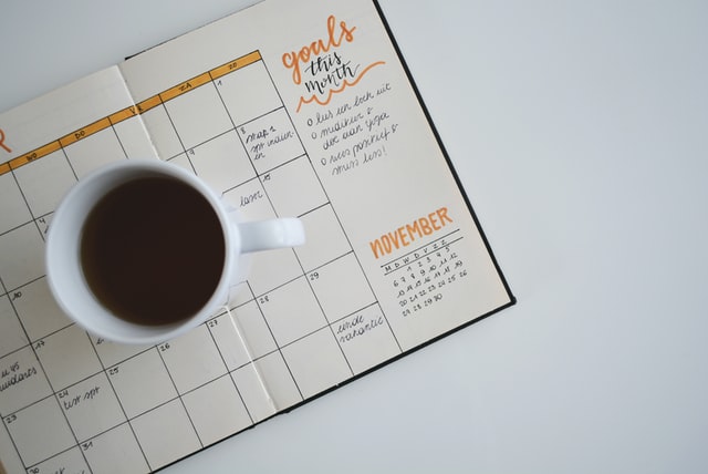 Ein Kalender auf dem eine Tasse Kaffee steht
