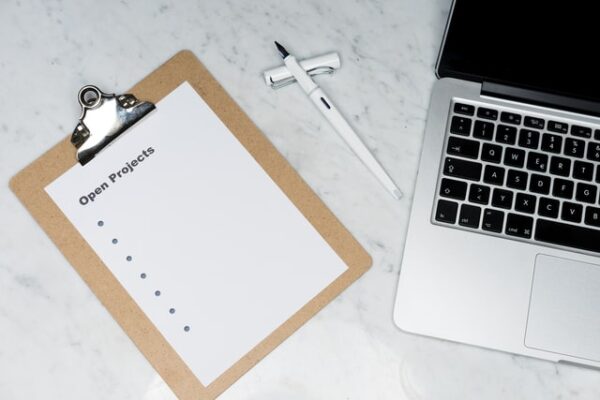 Woran arbeiten: Aufgabe, To-do oder Projekt? Neben einem Laptop liegt eine leere Liste mit Projekten