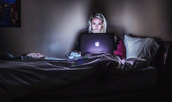 Nur wer auch mal entspannt, kann seine beste Leistung erbringen Jemand sitzt im Bett vor einem Laptop
