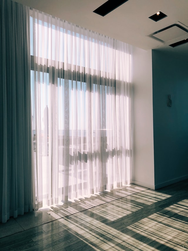 Ein lichtdurchlässiger Vorhang vor einem Fenster