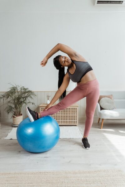 Ob in der Ecke, Garage oder Keller: ein Fitnessraum lässt sich überall einrichten Frau trainiert mit einem Gymnastikball