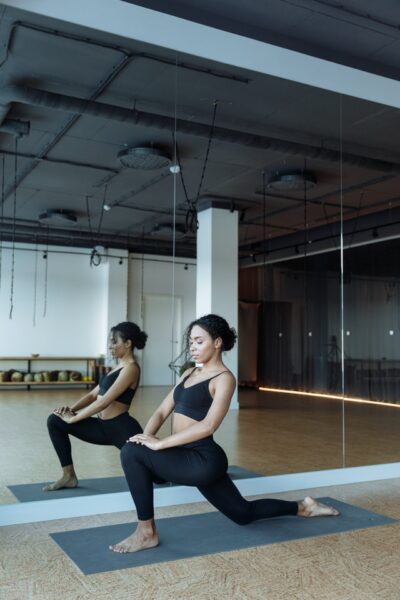 Im Fitnessraum ist ein Spiegel eine gute Idee Frau macht sportliche Übungen vor einem Spiegel