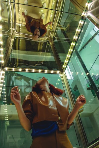 Frau in einem verspiegelten Aufzug