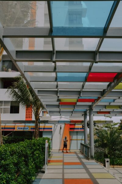 Bunte Folien zaubern wahre Kunstwerke Ein mit Glas überdachter Durchgang. Durch teilweise mit Folie beklebte Scheiben fällt buntes Licht auf den Boden