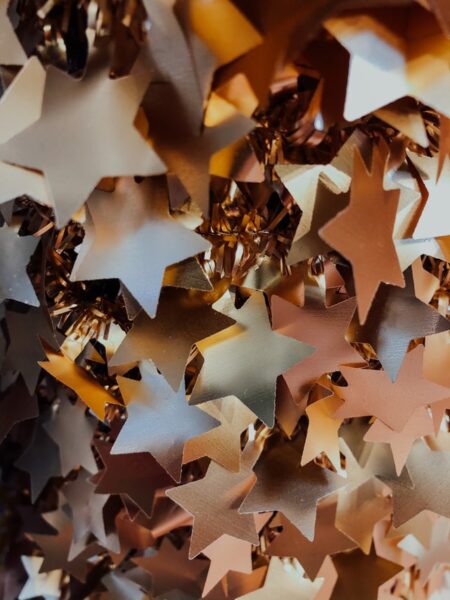 Aus Folie verschiedene Formen schneiden Viele goldene Sterne aus Folie dicht aneinander