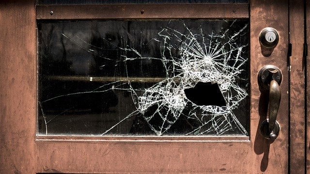 Ein kleines Fenster mit Holzrahmen und zerbrochener Scheibe