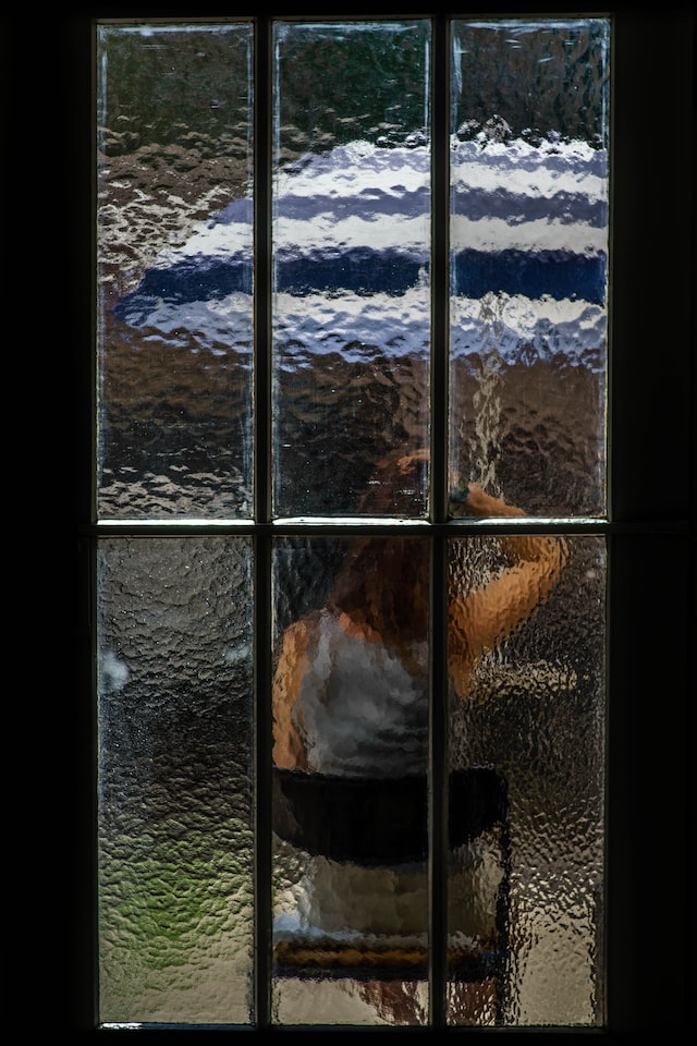 Eine Person sitzt hinter einer Glastür