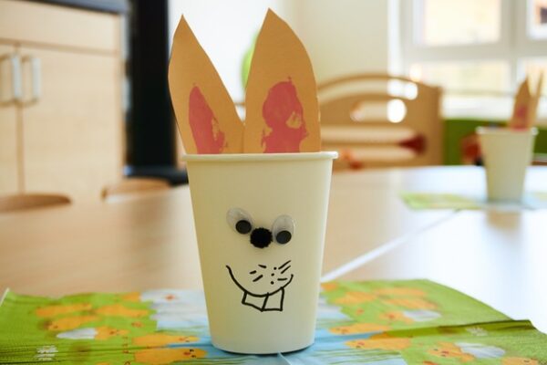 Verwerten Sie Reste und nutzen Sie sie zum Basteln zu Ostern Ein Becher, der als Hase dekoriert wurde