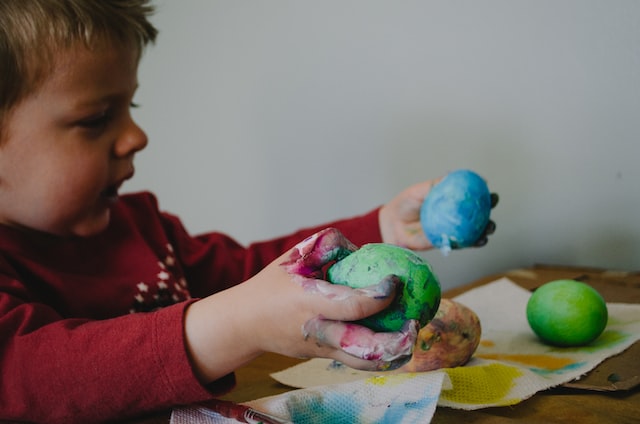 Kind hält bunte Eier in den Händen