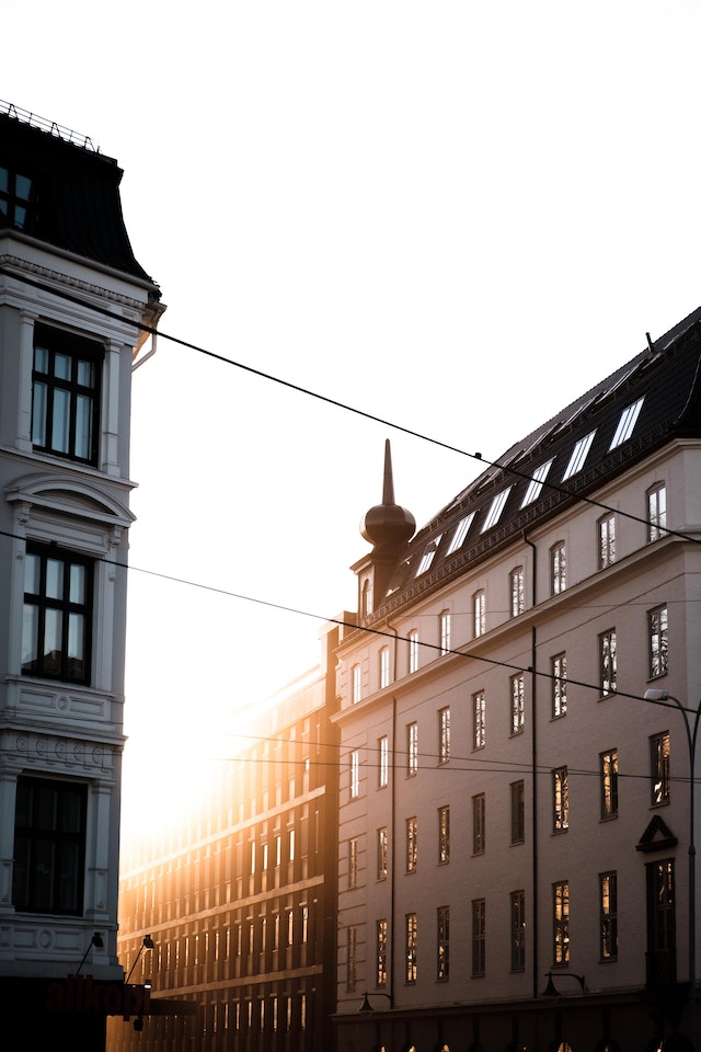 Zwischen zwei Häuserblöcken fallen erste Strahlen des Sonnenaufgangs hindurch