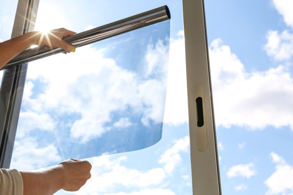 Fensterfolie anbringen: Jemand hält die Folie ans Glas