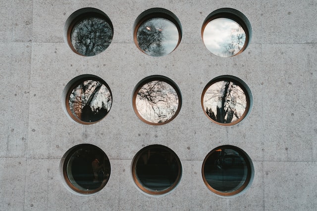 9 runde Fenster an einer Betonwand