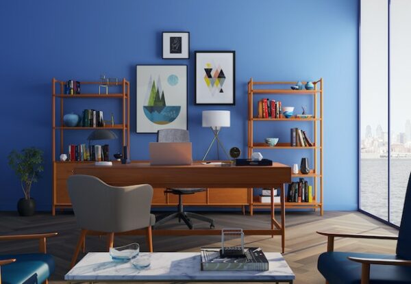 Ein Arbeitsplatz mit blauer Wand, braunen Holzmöbeln und mehreren Sitzmöglichkeiten 