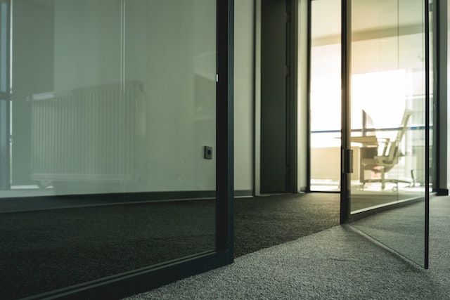 Ein Büro mit Glastüren und dunklem Teppich