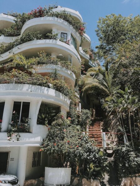 Pflanzen: die Sichtschutz-Idee am Balkon für Personen mit grünem Daumen Ein mehrstöckiges Haus mit gestuften Terrassen, die alle mit vielen Pflanzen bedeckt sind