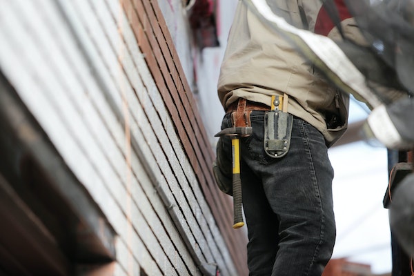 Ein Handwerker mit Hammer am Werkzeugsgürtel.