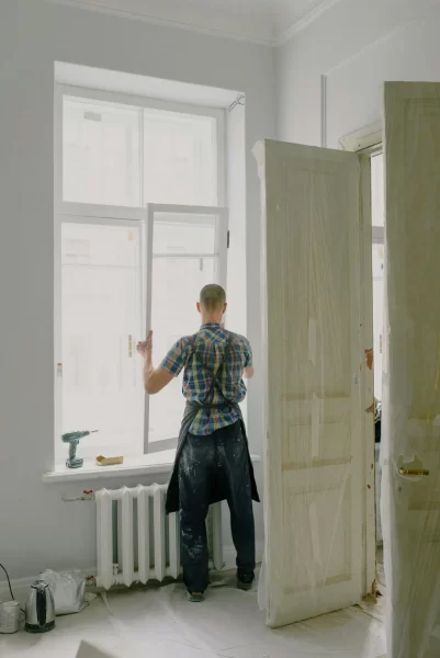 Handwerker montiert Fensterrahmen in hellem Raum während einer Renovierung.