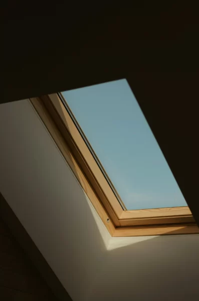 Dachfenster mit klarem Himmel und Holzrahmen.