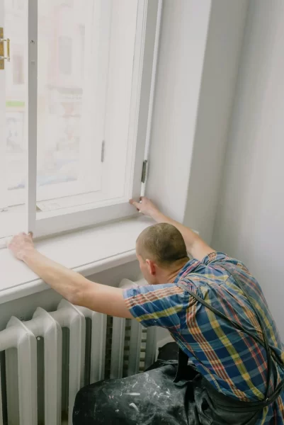 Handwerker montiert neues Fenster im Innenraum.