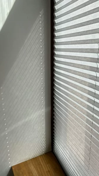 Innenliegendes Plissee am Fenster mit Schattenwurf.