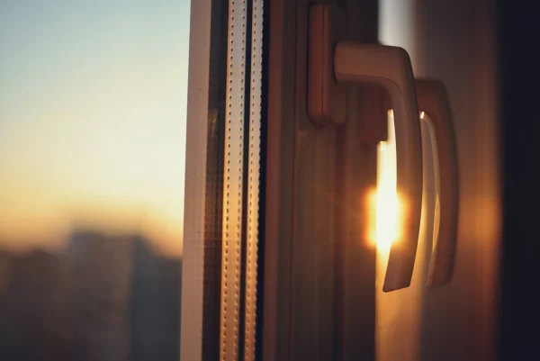 Sonnenlicht fällt durch ein Fenstergriff bei Sonnenuntergang