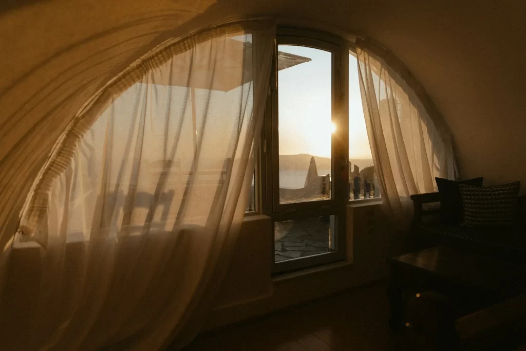 Sonnenlicht fällt durchs Fenster in einen Raum mit transparentem Vorhang