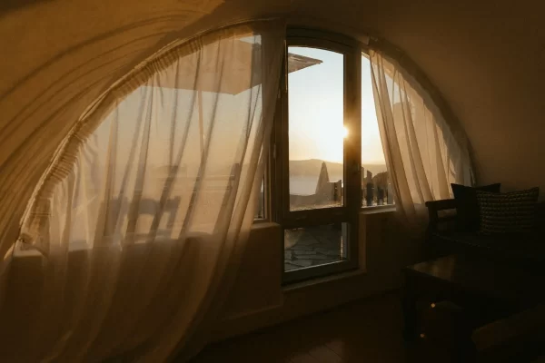 Sonnenlicht fällt durchs Fenster in einen Raum mit transparentem Vorhang