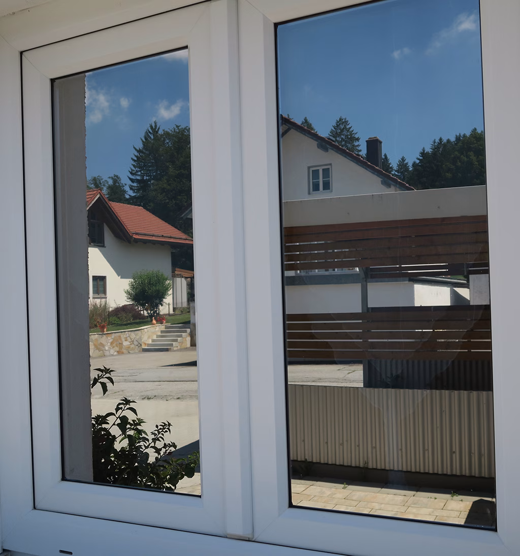 Außenansicht einer spiegelnden Sonnenschutzfolie auf zwei Fenstern