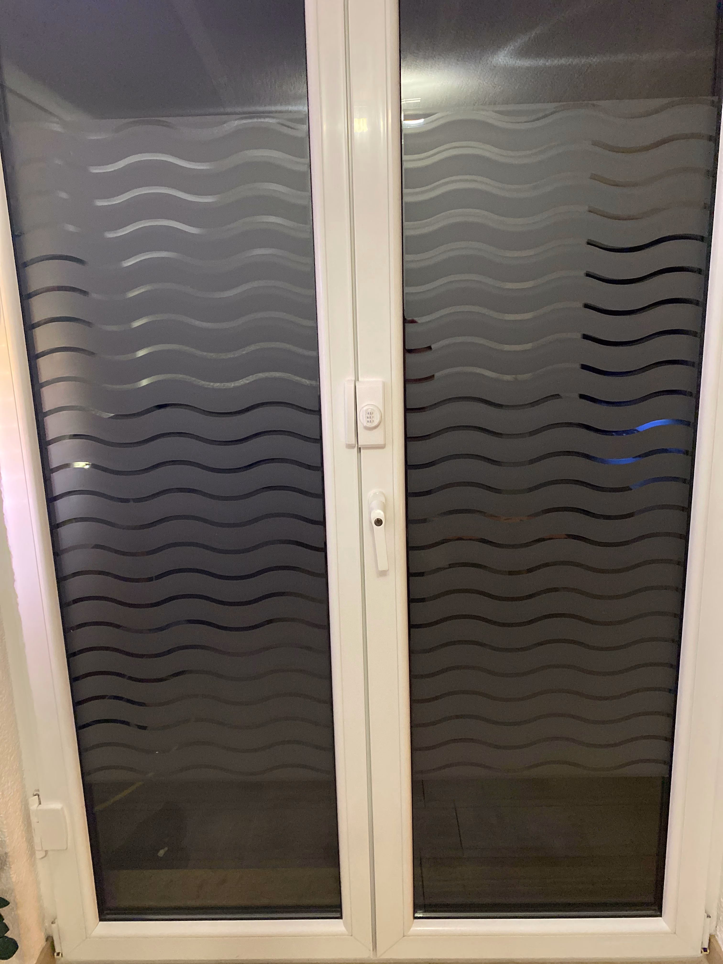 Fensterfolie mit weißen Wellen bei Dunkelheit aufgenommen