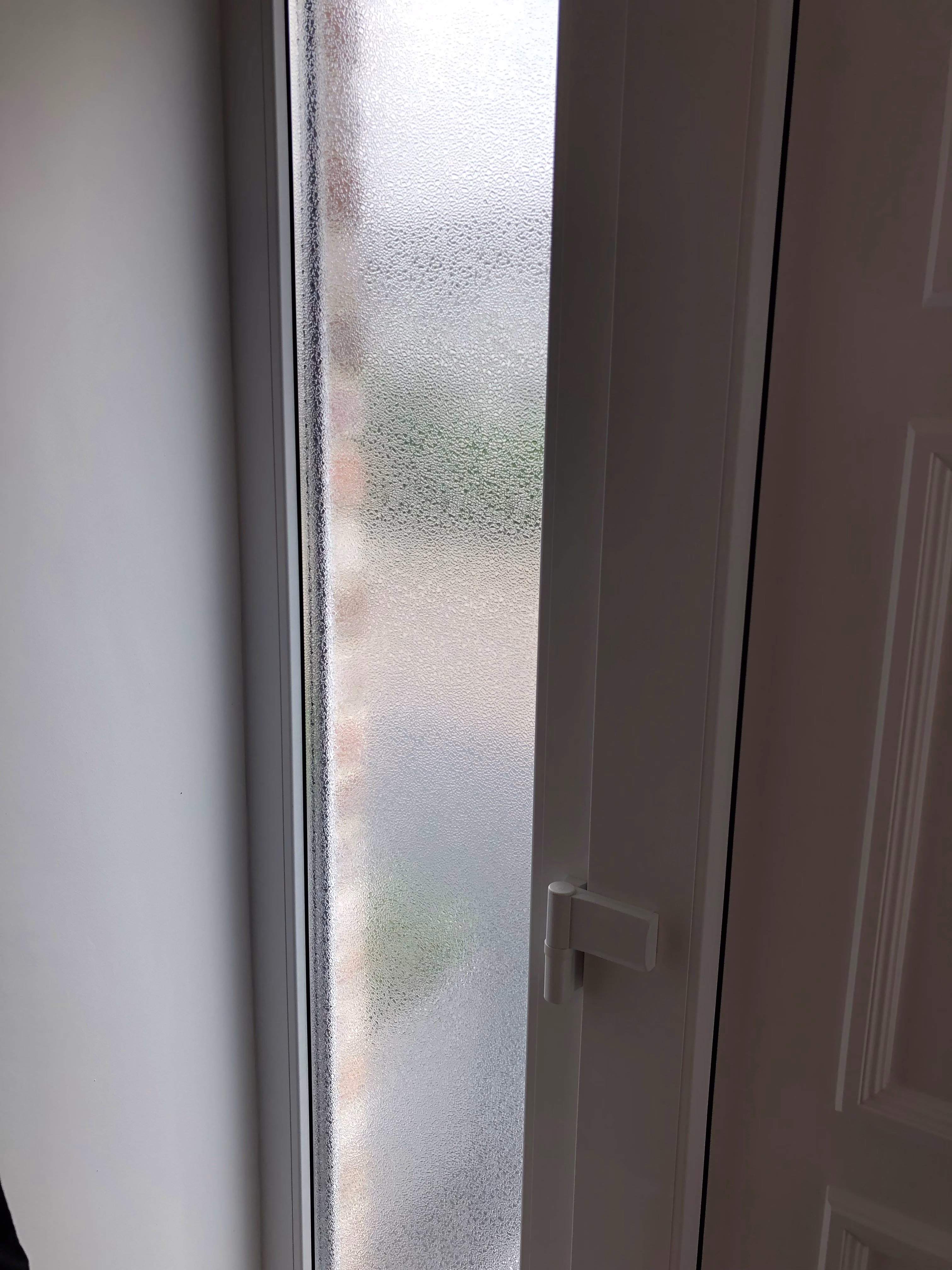 Adhäsionsfolie in Riffelglas-Optik auf dem Seitenfenster einer Tür angebracht