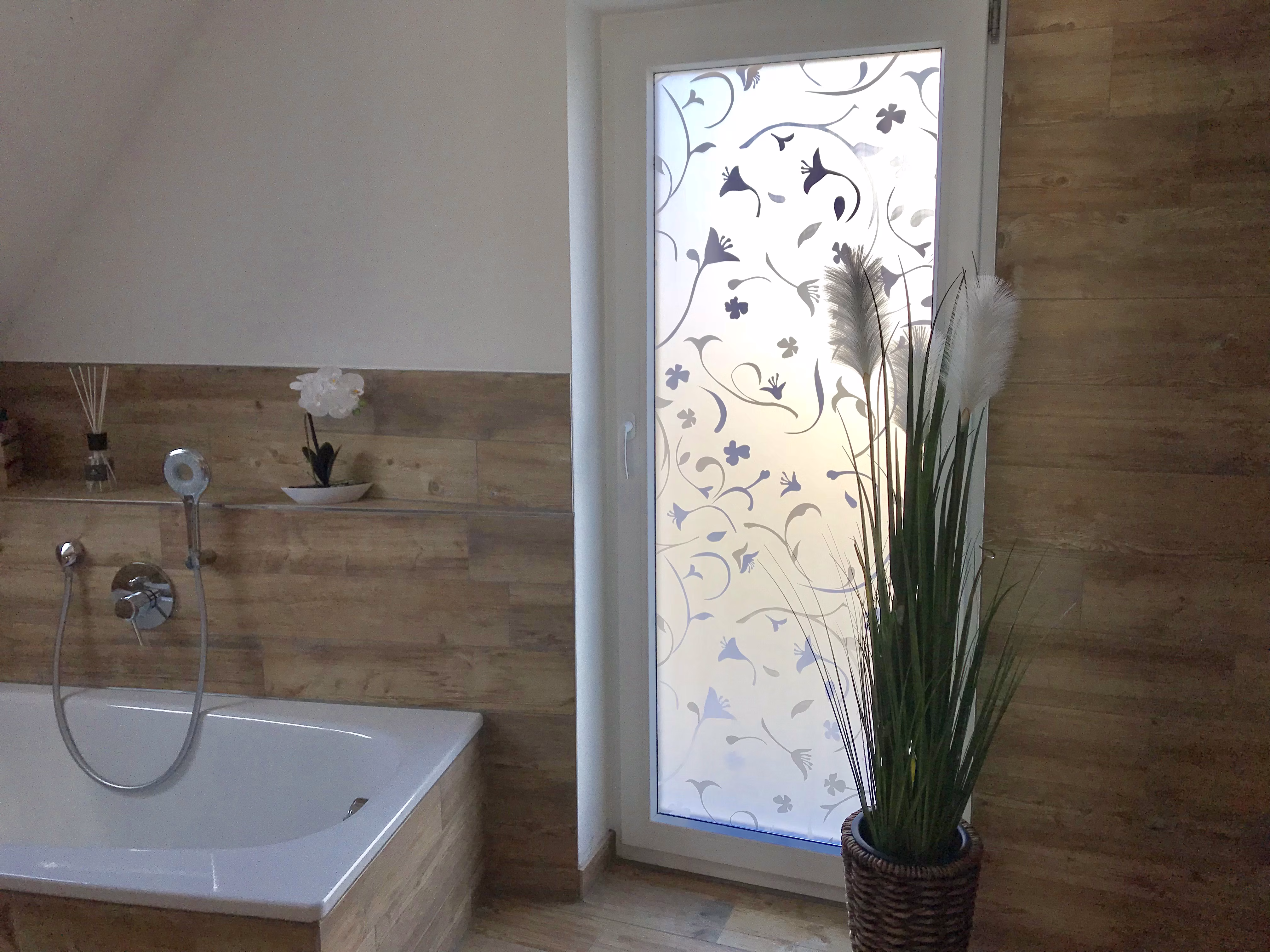 Adhäsionsfolie transparent matt mit weißen Blumen auf einem bodentiefen Fenster im Bad