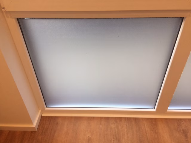 Kleberlose Sichtschutzfolie auf dem feststehenden Teil eines fensters im Wohnzimmer angebracht.