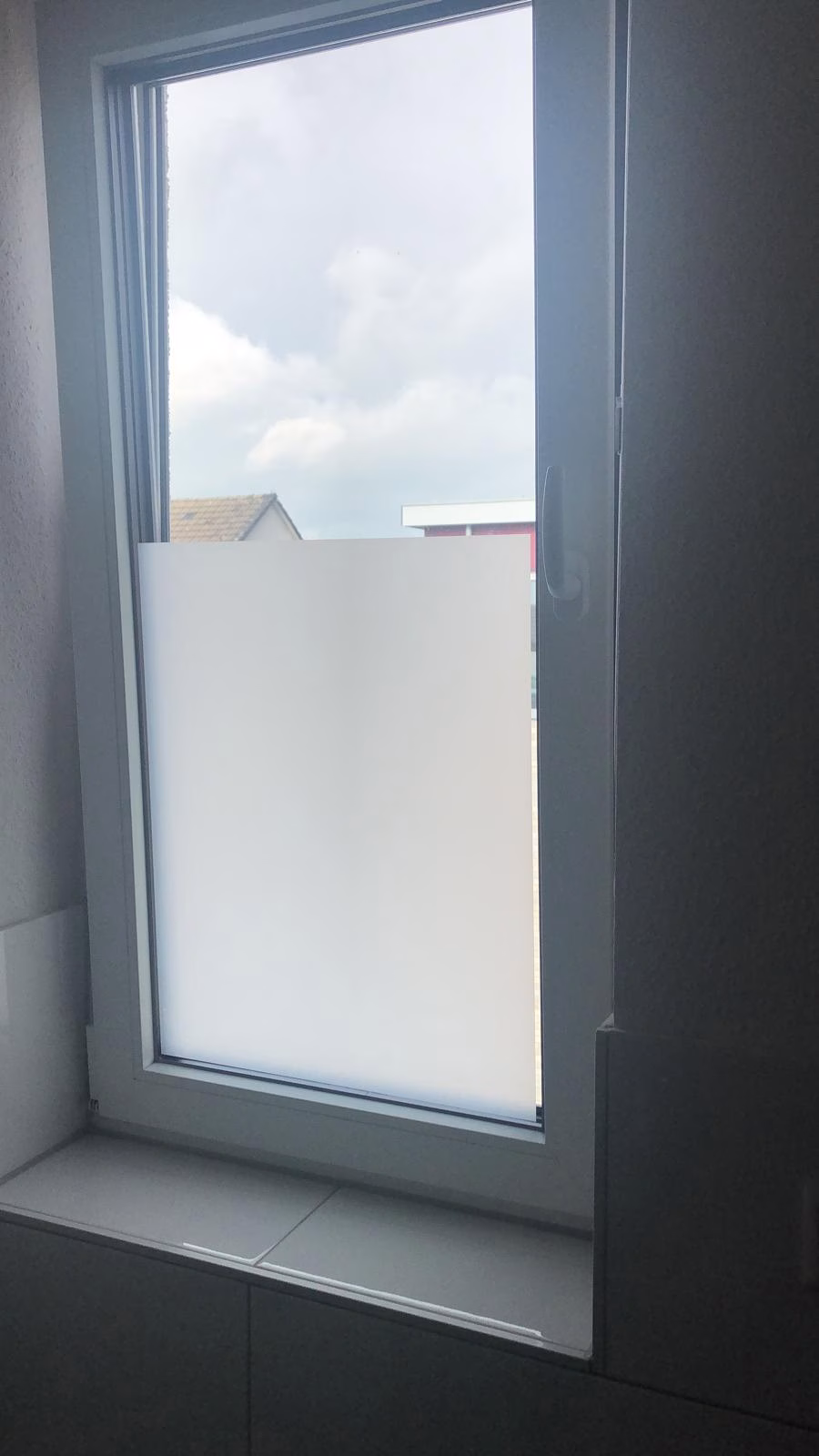 Sichtschutzfolie in Sandstrahloptik halbhoch auf Fensterglas montiert