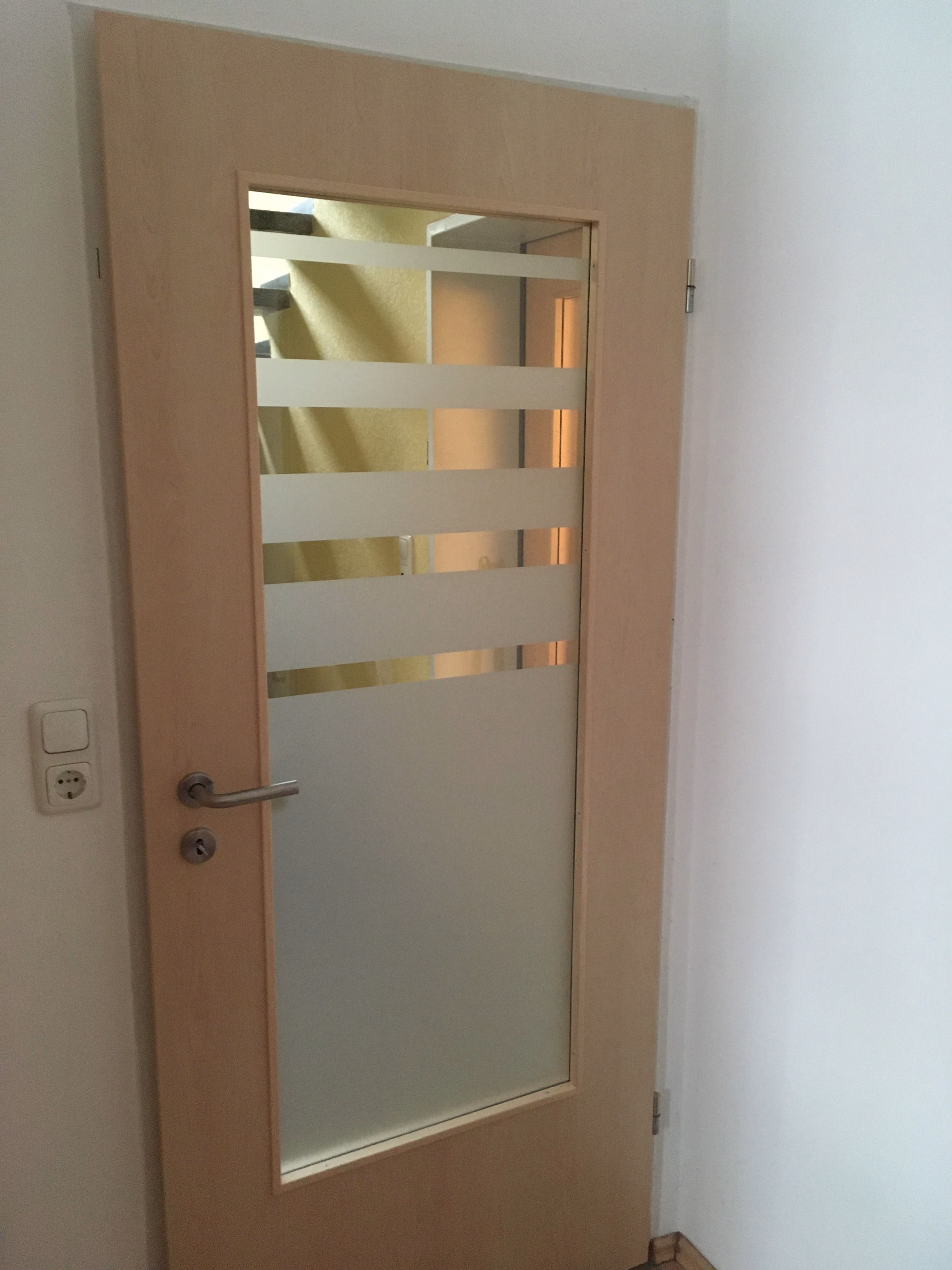 Glasdekorfolie mit Streifenverlauf als Sichtschutz auf den Glaseinsatz einer Tür angebracht