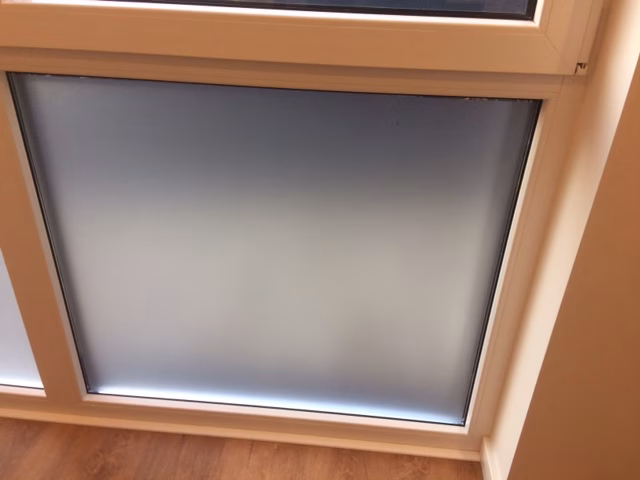 Selbsthaftende Sichtschutzfolie auf dem feststehenden Teil einer Fensterfront angebracht
