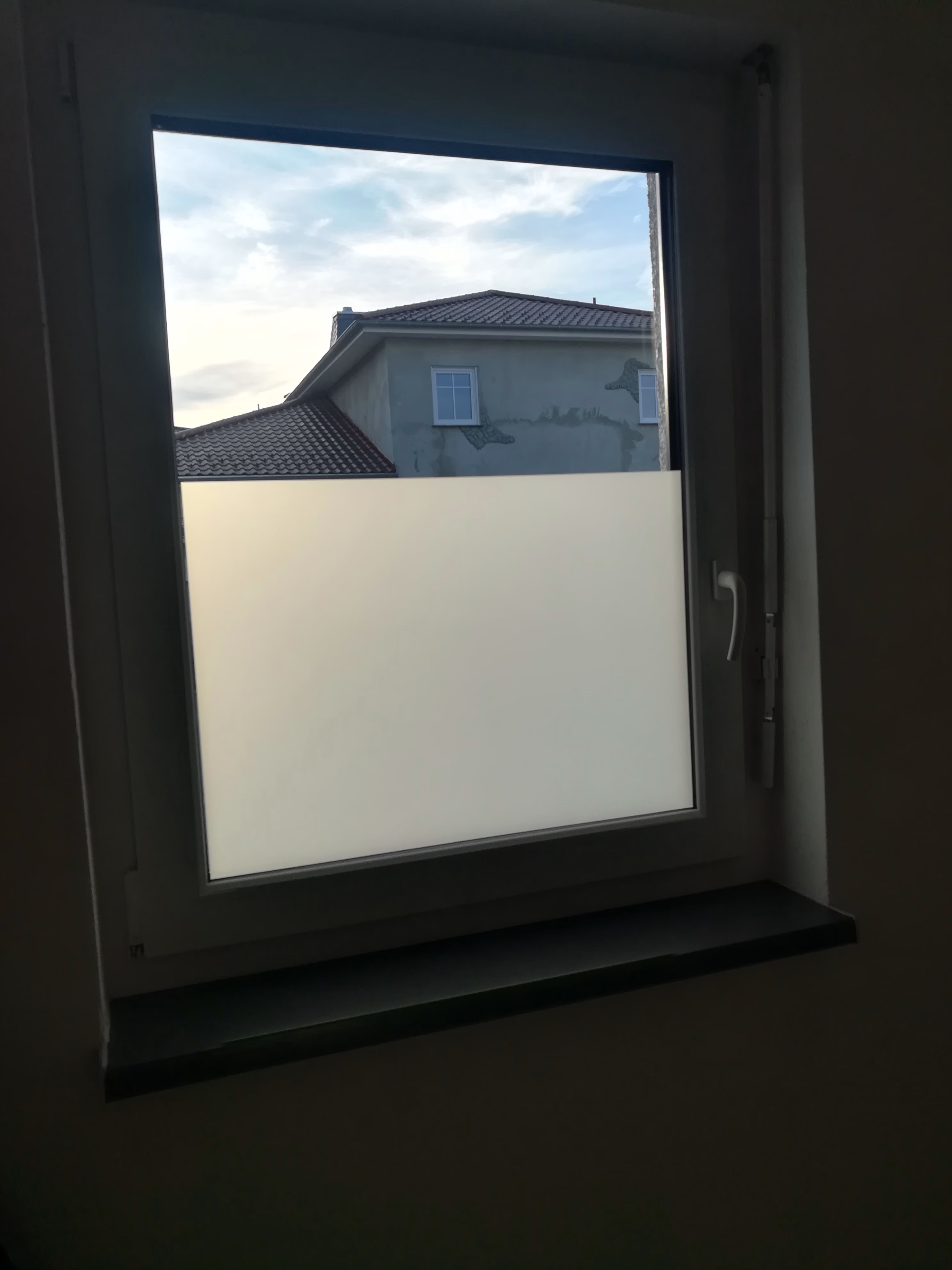 Dekorativer Sichtschutz durch eine Milchglasfolie am Fenster.
