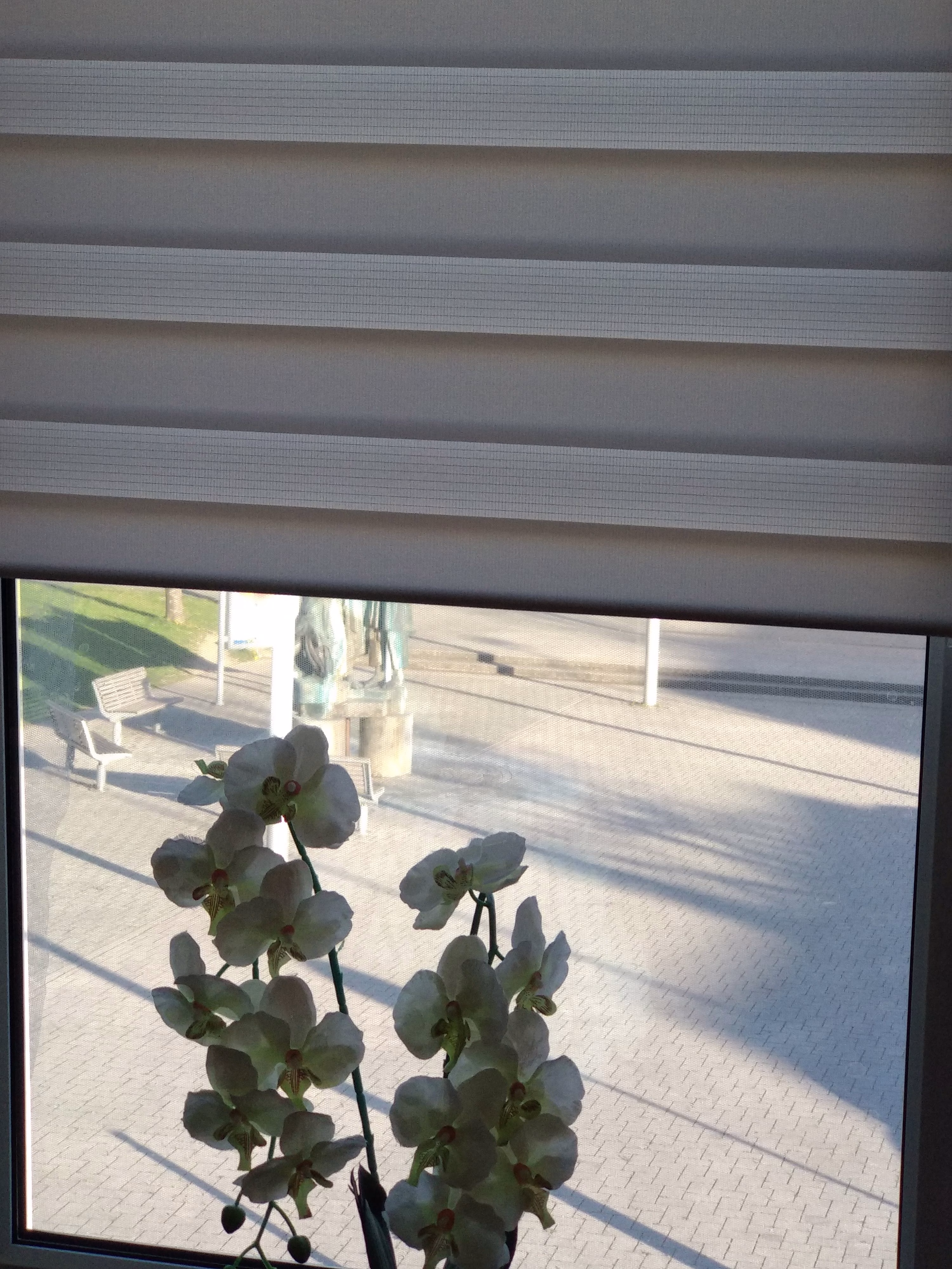 Sonnenschutzfolie silber mittel verspiegelt an einem Wohnzimmerfenster - Innenansicht