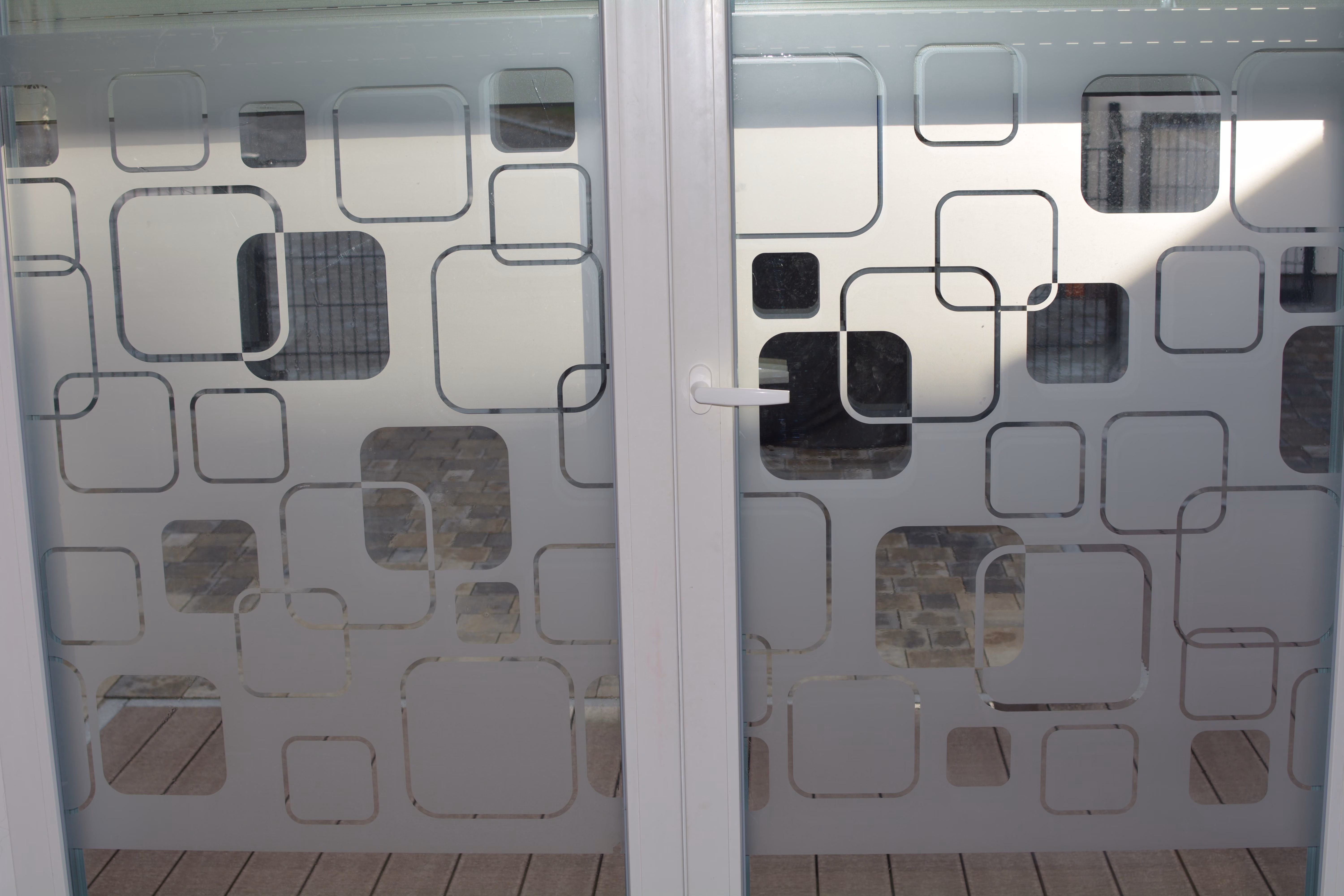 Dekorfolie mit abgerundeten Quadraten auf einer Glastür