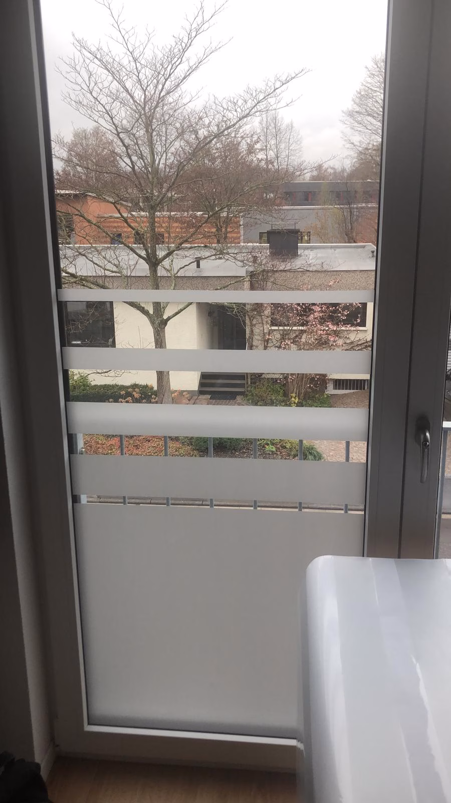 Glasdekorfolie mit unterschiedlich breiten Streifen auf einer Balkontür als Sichtschutz